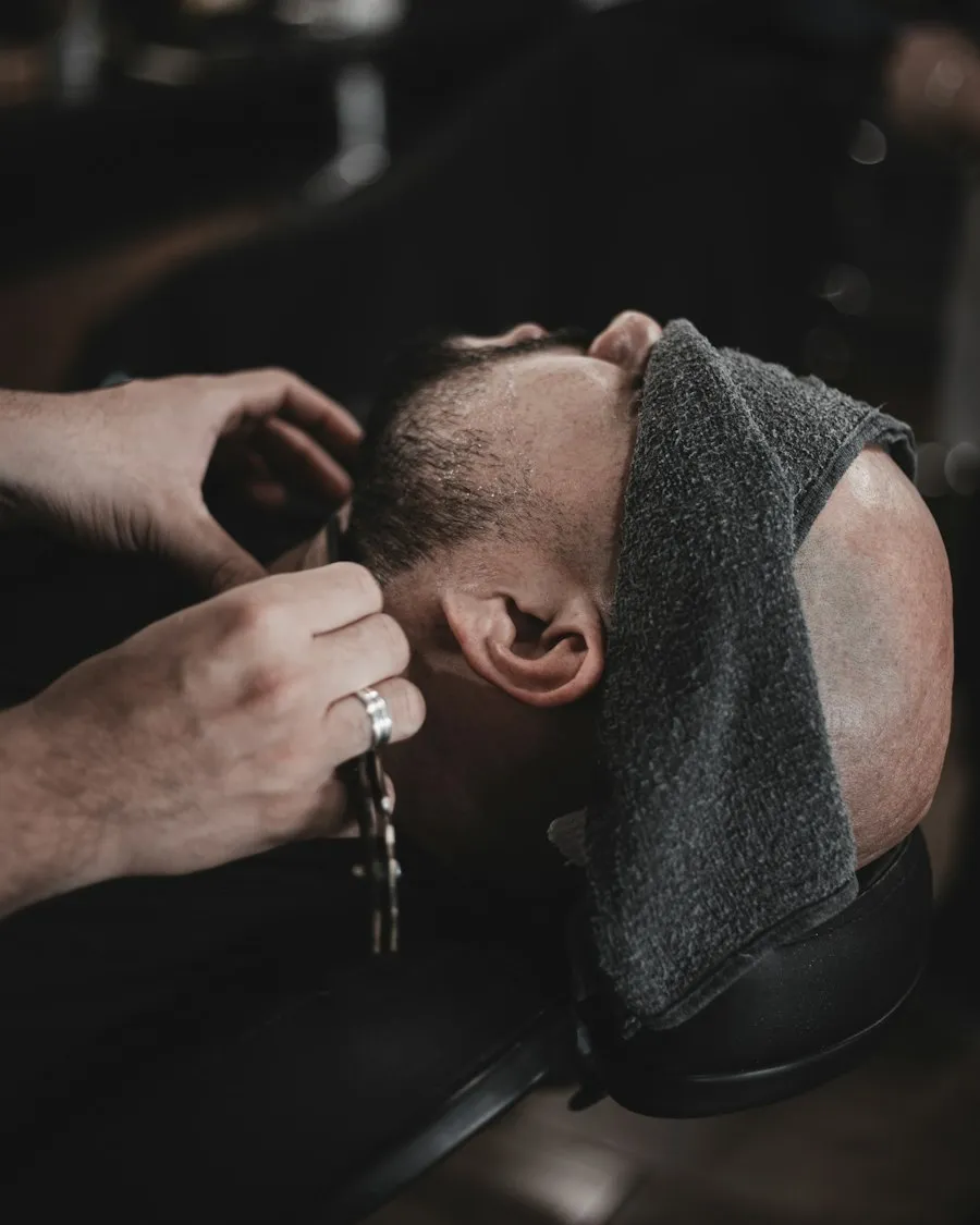 Cliente com a toalha quente no rosto antes da barba
